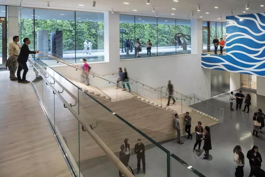 Pessoas sobem e descem escadas em um átrio arejado do Museu de Arte Moderna de São Francisco (SFMOMA).